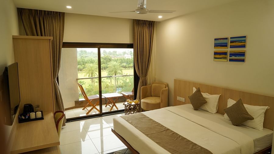 Pride Ranakpur Resort Convention Centre - Interior view of the suite featuring a king size bed a television and a balcony containing a coffee table