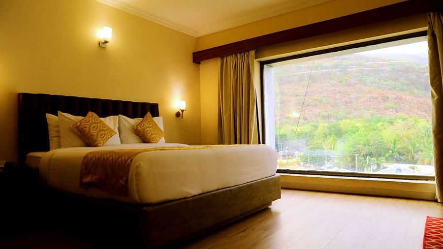 Bedroom with large window and mountain view.