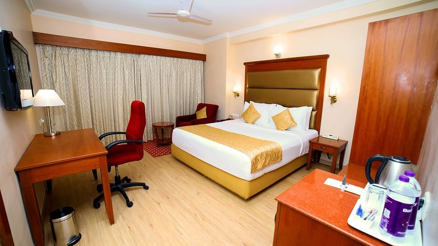 Bedroom with bed, desk, and seating area.