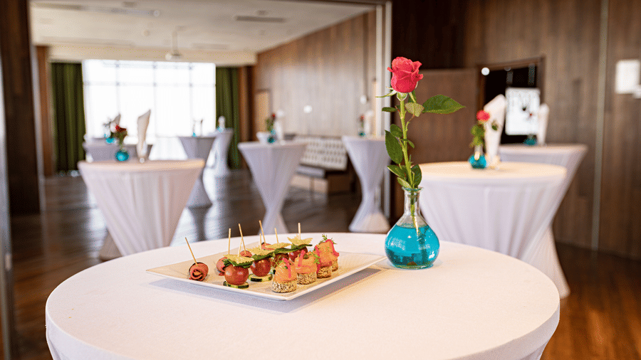 An overview of an event space with many round tables having a vase on it inside at Ramada by Wyndham Addis, Addis Ababa.