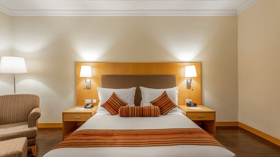 Superior Room, one of the best hotel hotel rooms near Bole Airport, featuring a double bed with side tables and lamps above each of them at Ramada by Wyndham Addis