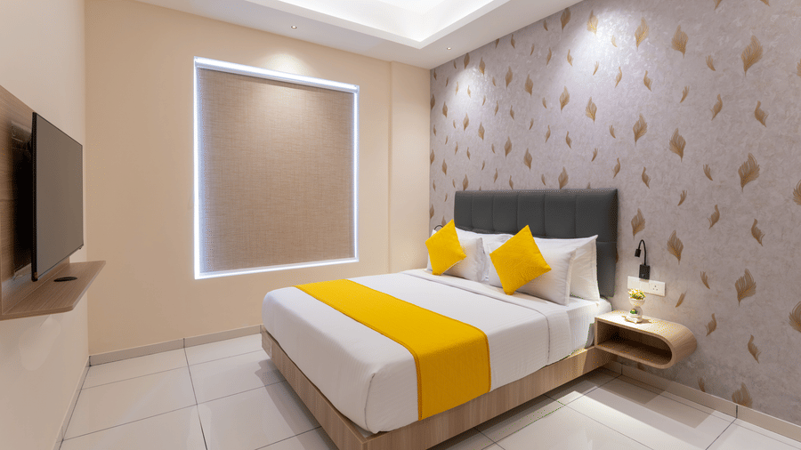 Modern bedroom featuring yellow accent cushions and elegant wall design at Rivido - Manyata