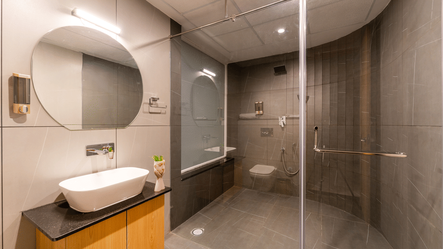 Contemporary bathroom with glass-enclosed shower and modern vanity unit at Rivido - Manyata