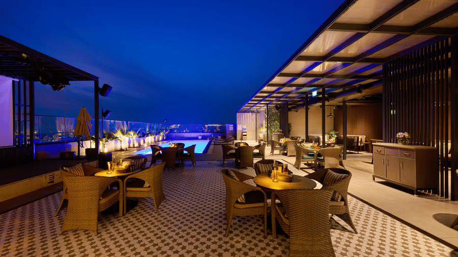 Rooftop dining area at Riviera Sarovar Portico, Pathankot featuring outdoor seating, warm evening lighting and a stylish ambience ideal for relaxed dinners.