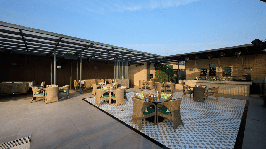 Open air rooftop seating at Riviera Sarovar Portico, Pathankot with modern furniture and city views, perfect for casual dining and evening gatherings.