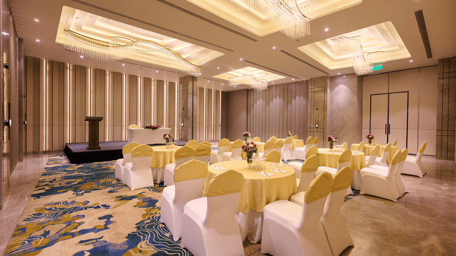 Grand banquet setup at Riviera Sarovar Portico, Pathankot with elegant decor, floral table settings and ample space for formal events.