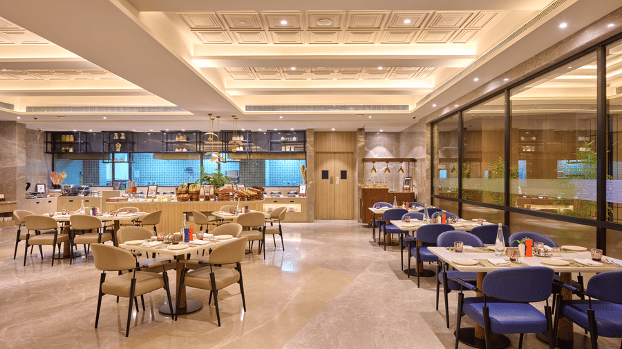 Indoor restaurant at Riviera Sarovar Portico, Pathankot showcasing contemporary seating, warm lighting and a refined space for all day dining.