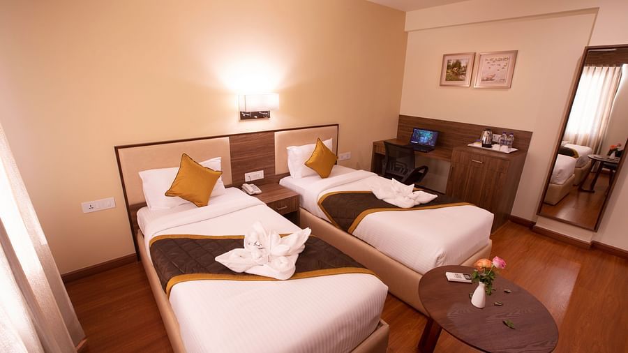 room with twin beds at rk gardenia, surya city