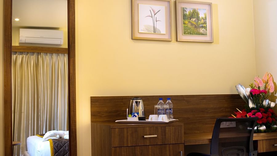 Inviting bedroom with a soft double bed, warm décor, and a well-lit ambience - RK Gardenia, Surya City.