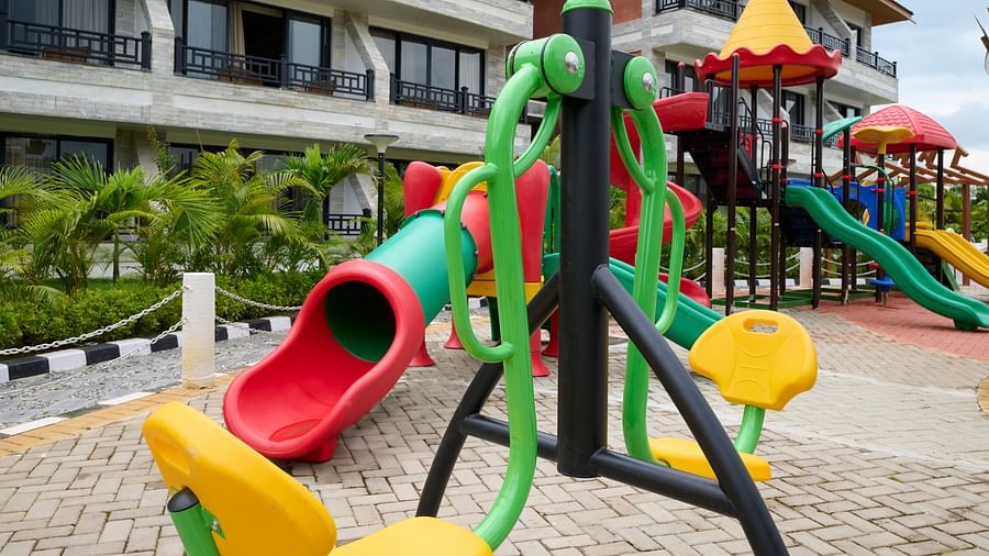 Children's play area with colourful slides and swings in front of the resort - Royal Tulip, Chitwan