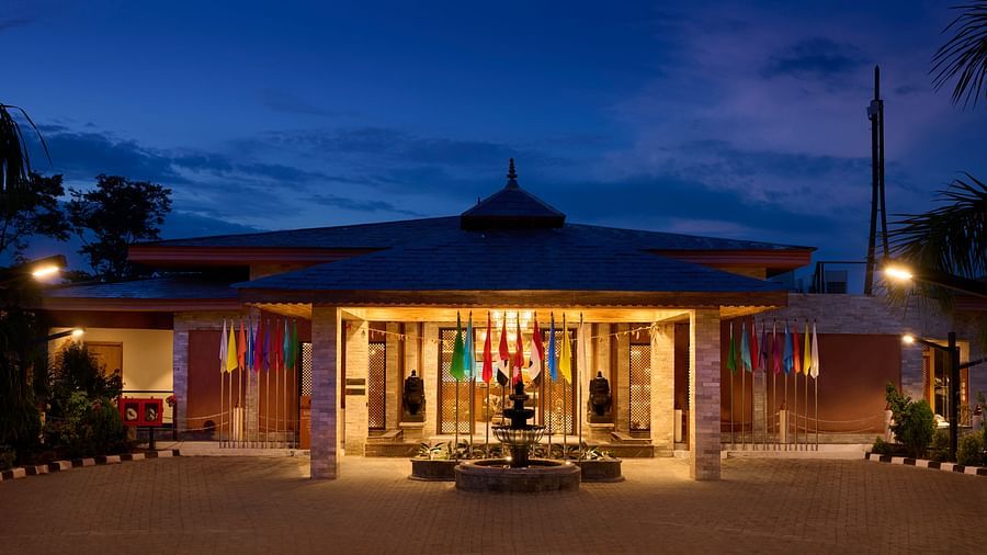 A close up of a hotel entrance at night with lights highlighting the welcoming facade - Royal Tulip, Chitwan