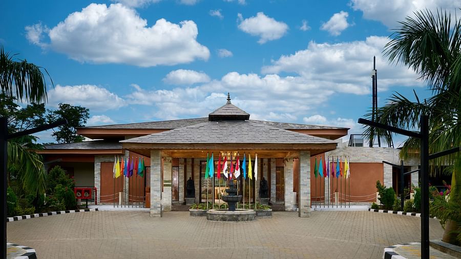 Hotel exterior with lush greenery and colourful decor surrounding the entrance - Royal Tulip, Chitwan