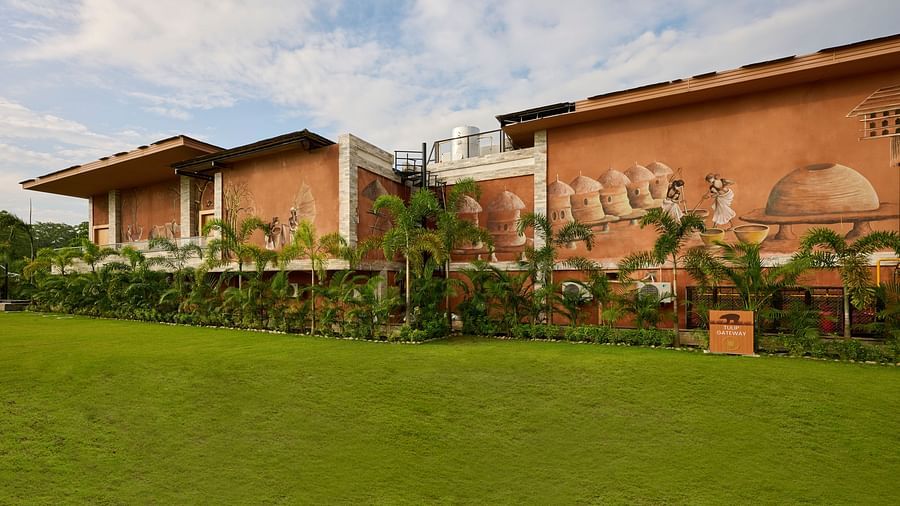 A multi-storey building featuring potted plants and a lush green lawn in front - Royal Tulip, Chitwan