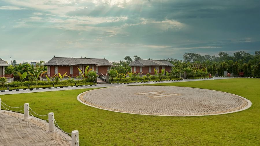 Hotel exterior featuring a round open lawn area with clear skies above - Royal Tulip, Chitwan