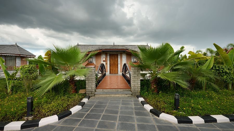 The entrance to a cottage-style accommodation in Chitwan, lined with plants on either sides - Royal Tulip, Chitwan