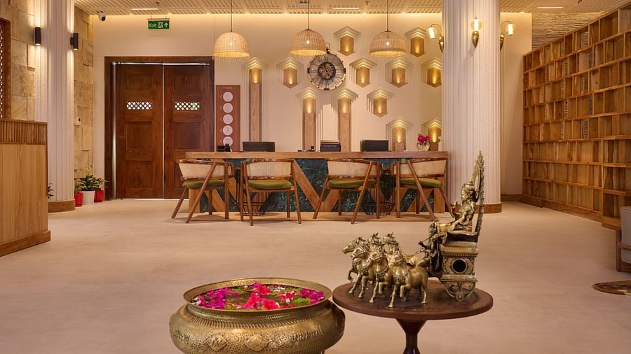 A reception area with wooden decor, a urli bowl, and warm lighting - Royal Tulip, Chitwan
