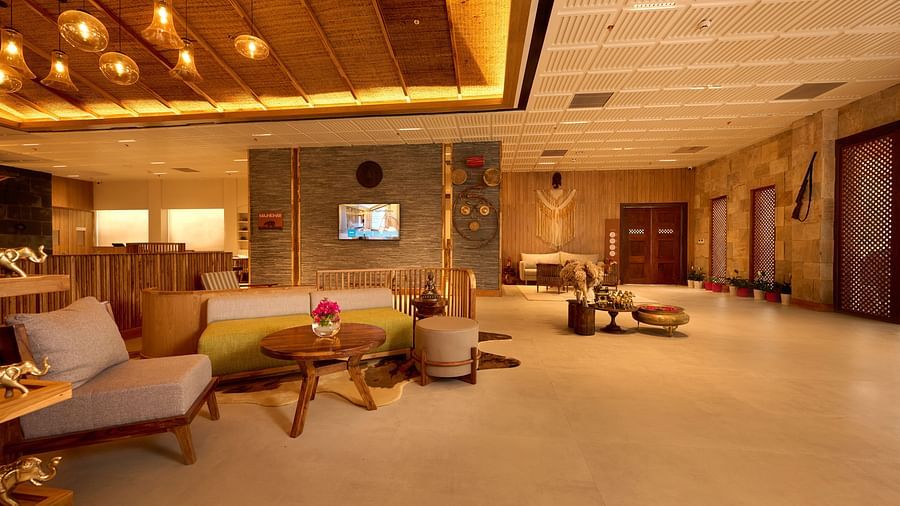A hotel lobby area with upholstered chairs and couches, a television, and warm ceiling lights - Royal Tulip, Chitwan