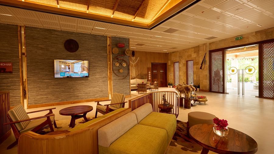 Cosy waiting area in the hotel with modern wooden furniture and decorative lighting - Royal Tulip, Chitwan