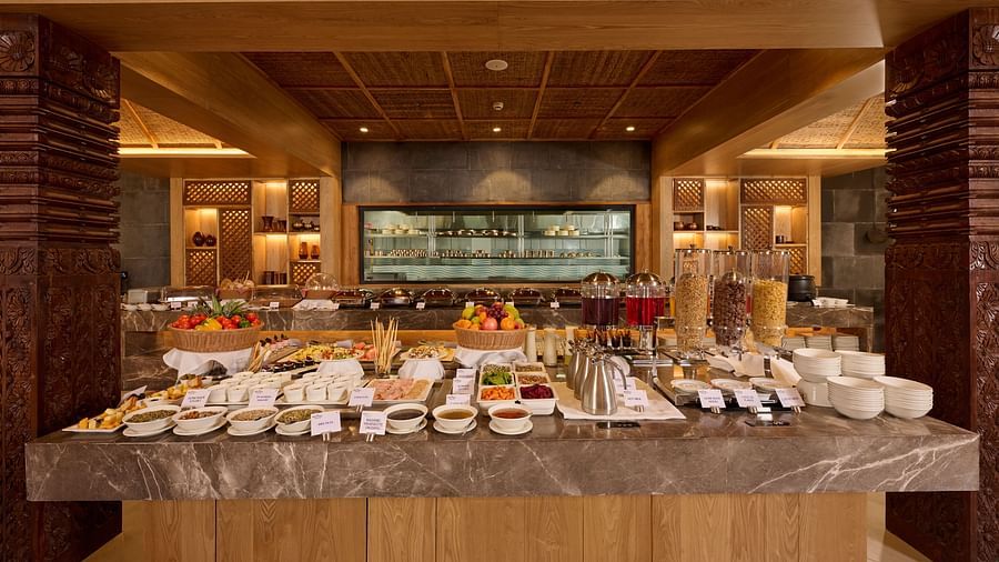 Full view of breakfast buffet setup in a warmly lit dining area - Royal Tulip, Chitwan