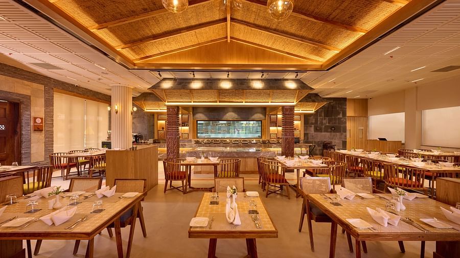 Indoor dining space with square tables and modern wooden ceiling design - Royal Tulip, Chitwan