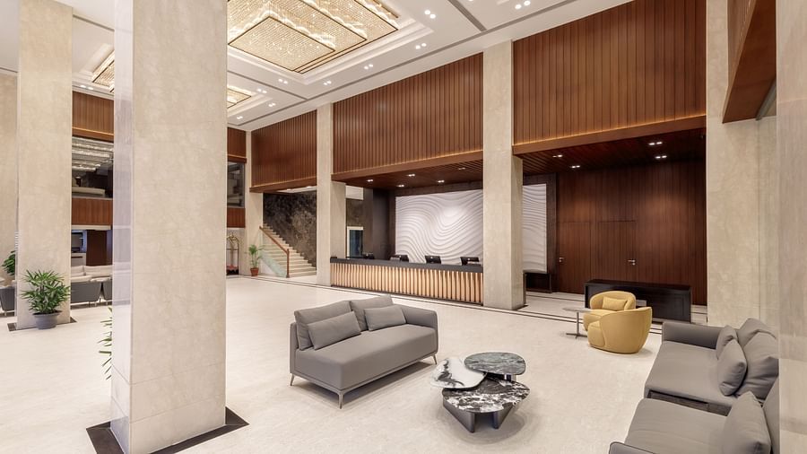 The grand lobby of Royal Tulip, Kathmandu, featuring a reception desk, comfortable seating, and ornate ceiling lights.