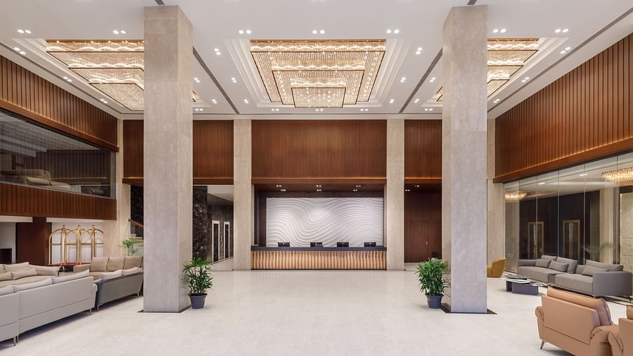 The impressive, spacious lobby of Royal Tulip, Kathmandu, with a central reception desk and elegant lighting.