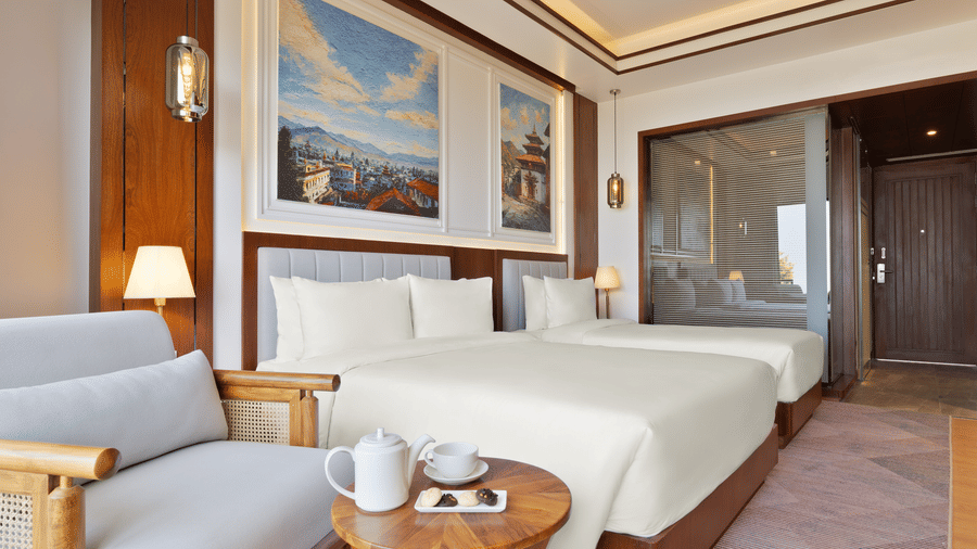 Executive Room at Royal Tulip Shivapuri National Park - Kathmandu with plush bedding, a sitting area, and framed art on the wall.