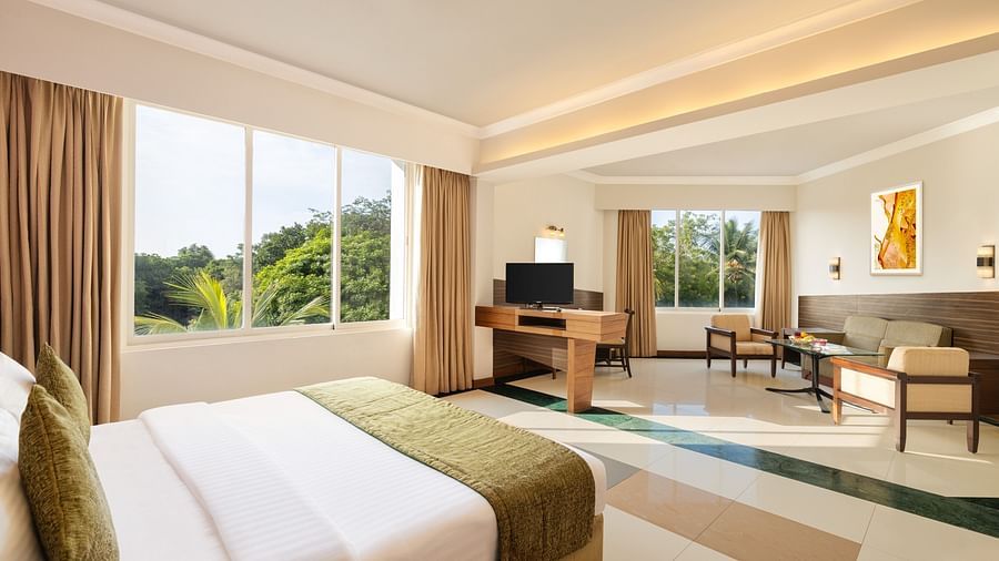 Double bed and seating arrangement in Deluxe Room at Sangam Hotel, Thanjavur