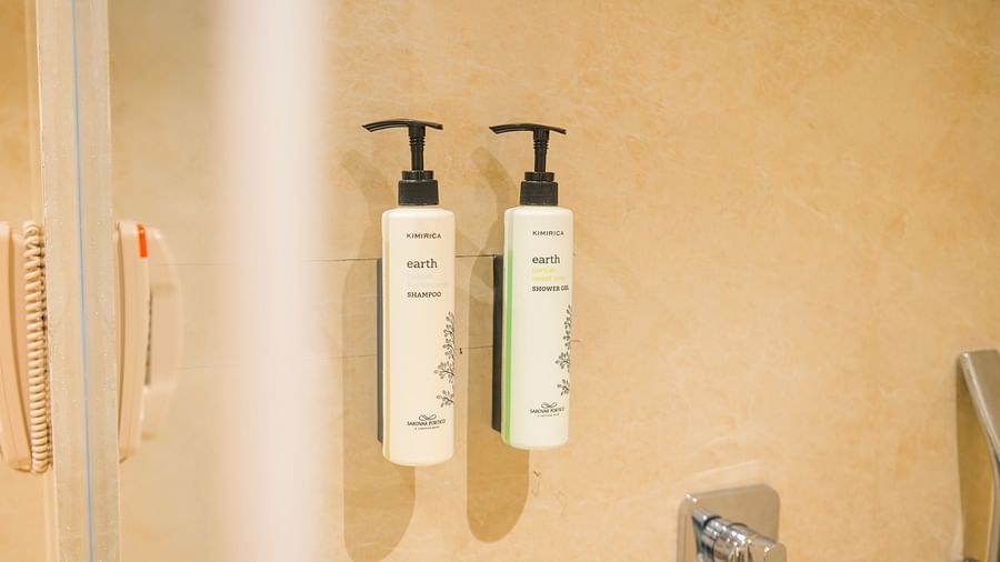 Wall-mounted toiletries and shower area in the Superior Room bathroom at Sarovar Portico, Ajmer.
