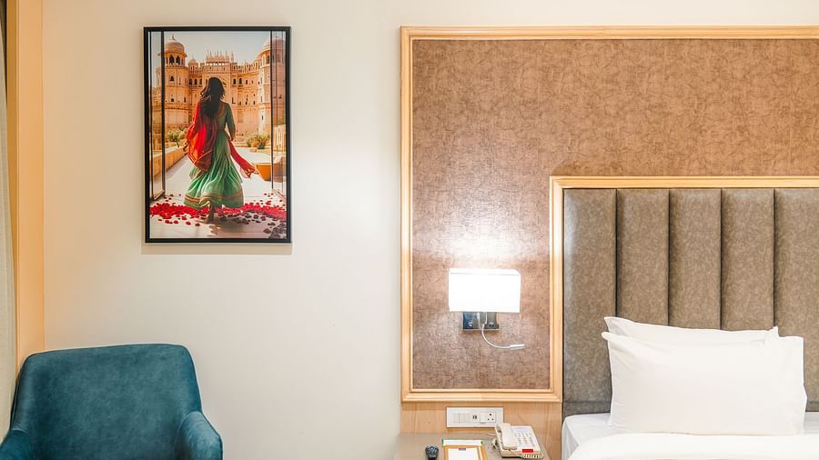 Superior Room with plush bedding and accent chair at Sarovar Portico, Ajmer.