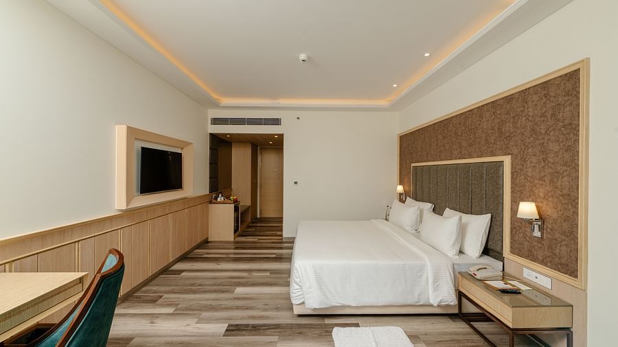 A spacious hotel room with a king size bed, modern amenities, and stylish lighting to create a welcoming atmosphere