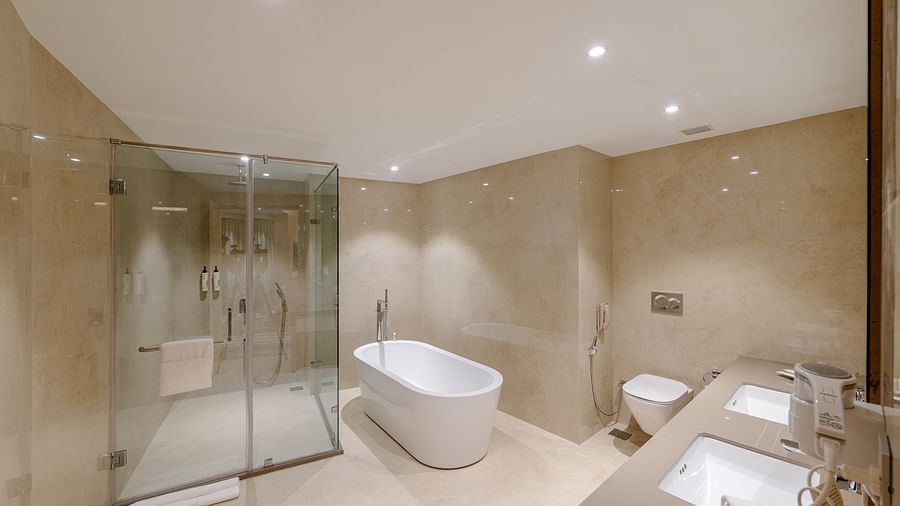 A modern bathroom with a bathtub, a shower cubicle, and a large sink - Sarovar Portico, Ajmer
