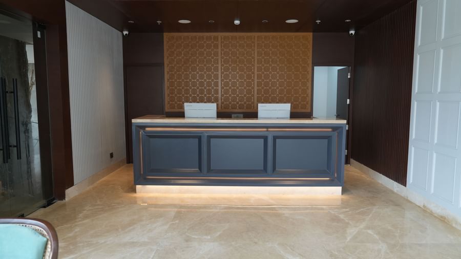 A spacious hotel lobby is furnished with multiple seating groups and a reception desk in the background | Sarovar Portico, Hanumangarh
