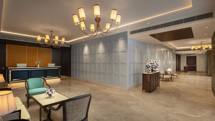 A large hotel lobby and front desk at Sarovar Portico, Hanumangarh, with sofas, chairs, and lamps.