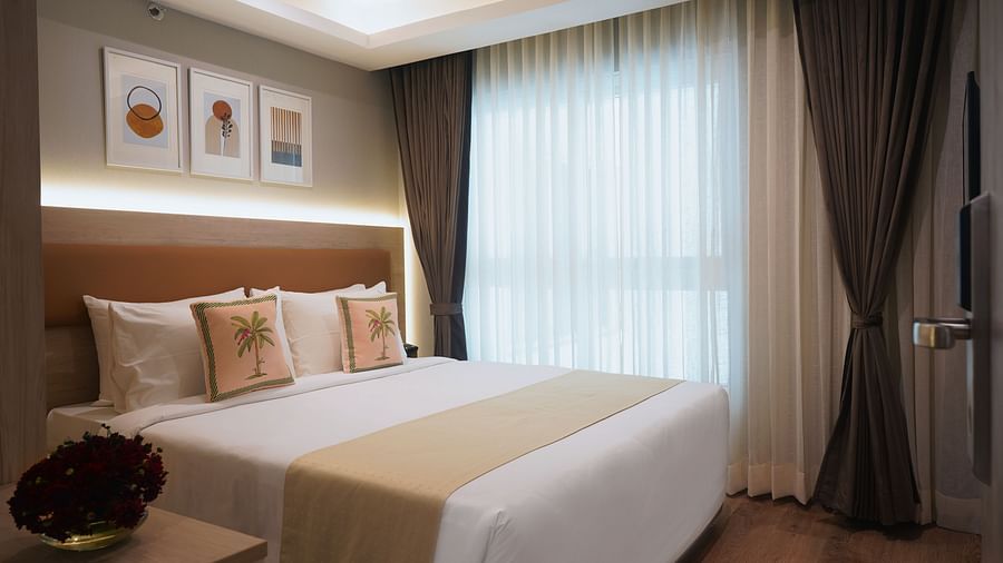 view of the double bed and a side table inside the suite at Sarovar Portico, Kolkata Rajarhat