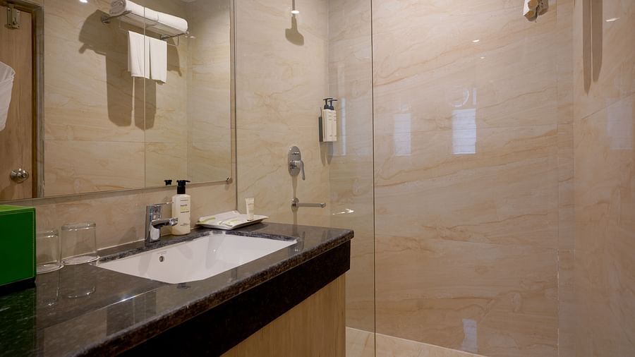 view of the shower area and vanity section in the washroom of one of the rooms at Sarovar Portico, Kolkata Rajarhat