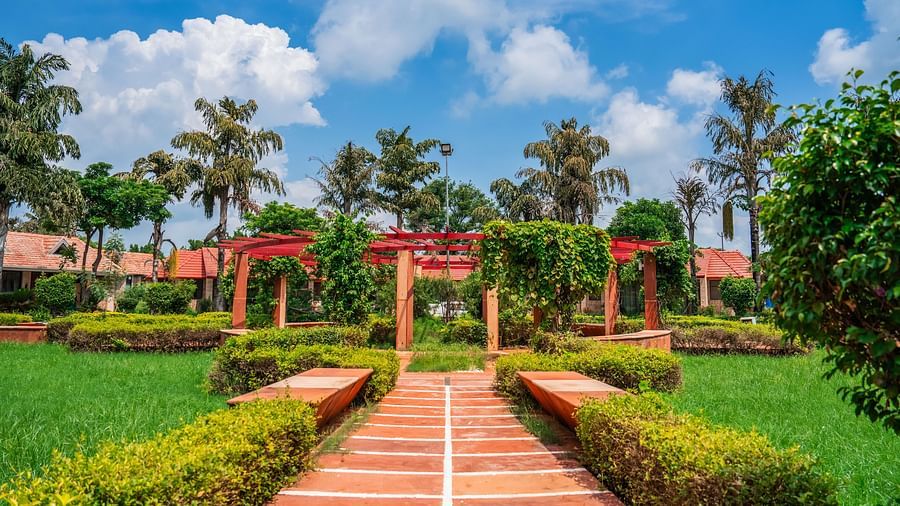 Scenic pathway leading to a luxurious resort surrounded by lush greenery.