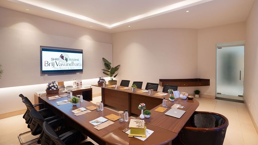 Modern conference room with a projector screen and comfortable seating at Shri Radha Brij Vasundhara Resort & Spa, Mathura