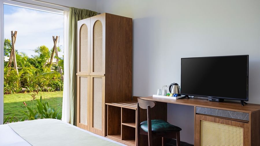 image of garden suite bedroom featuring a flat screen television and a closet besides the french windows