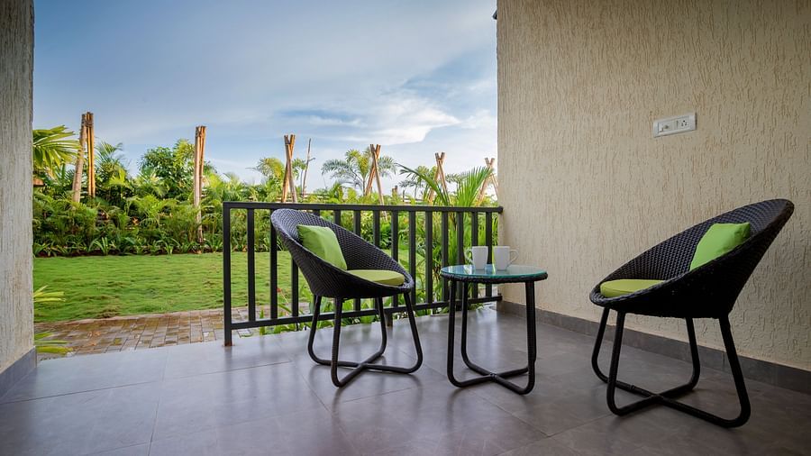image of the private balcony with an amazing view of lush green garden with two chairs in the borch along with a coffee table