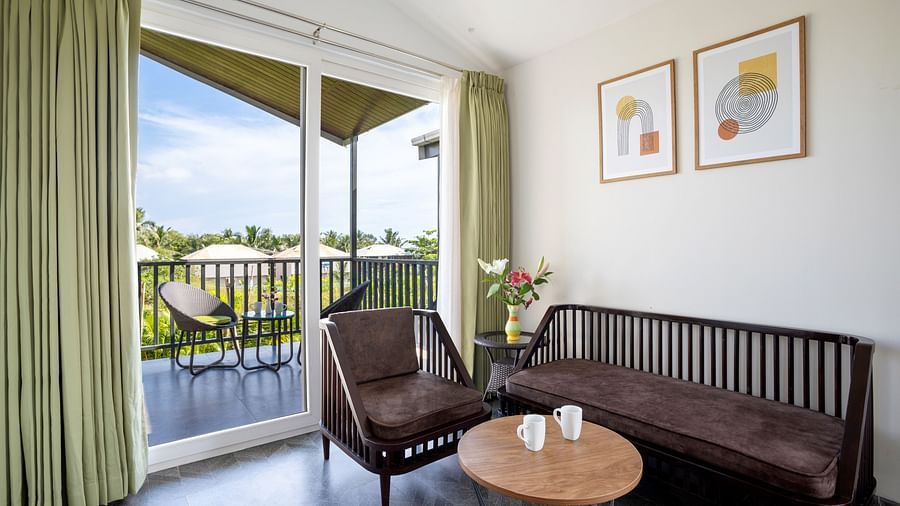 image of the living area with huge french windows that open to the outdoor sit out area at the ocean suite