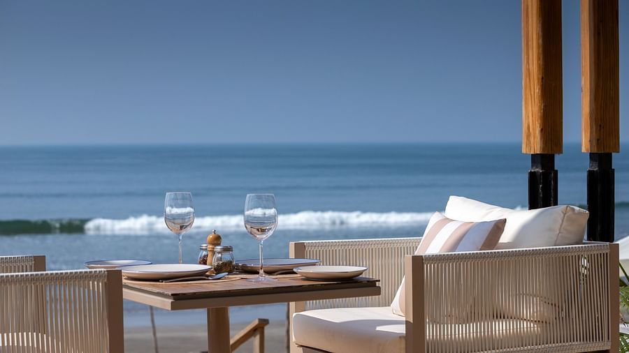close up image of a chair with white cushion with a serene background of blue ocean