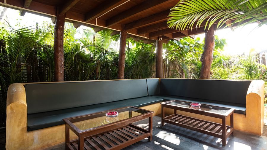 image of the lobby at sibaya beach resort, morjim beach that features a huge outdoor couch with two glass top centre tables in front of it