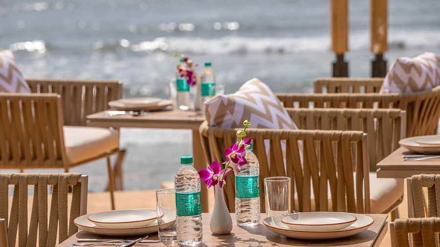 close up image of the saz on the beach restaurant with packed drinking water bottles and cutlery kept on the table