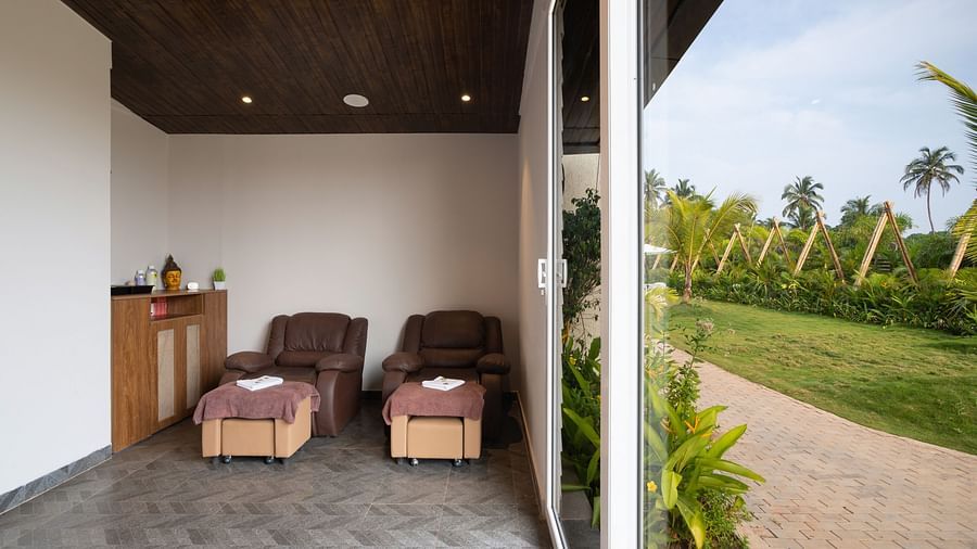 image of the spa with two cushioned massage chairs besides lush green lawn 