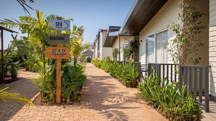 exterior image of sibaya beach resort, morjim beach with a pathway leading to all the cottages and signboard in the middle