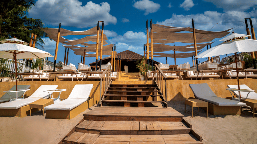The front view of the entrance of the In-House Restaurant featuring white coloured sun loungers at the entrance