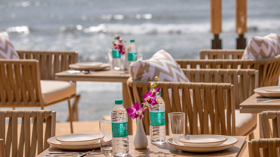 The close up image of the In-House Restaurant with packed drinking water bottles and cutlery kept on the table