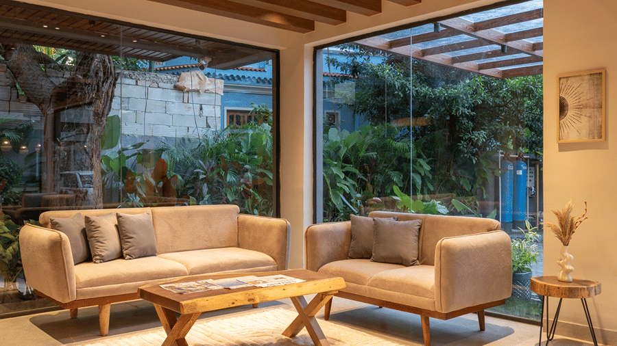 Cosy indoor lounge area with plush sofas and large glass windows overlooking lush greenery at Sibaya Courtyard .