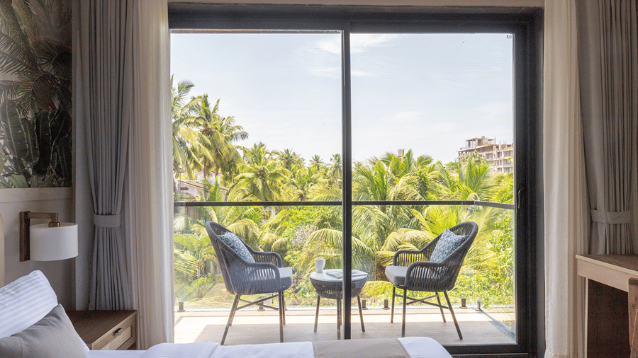 Balcony view from a guest room overlooking lush green palm trees at Sibaya Courtyard.